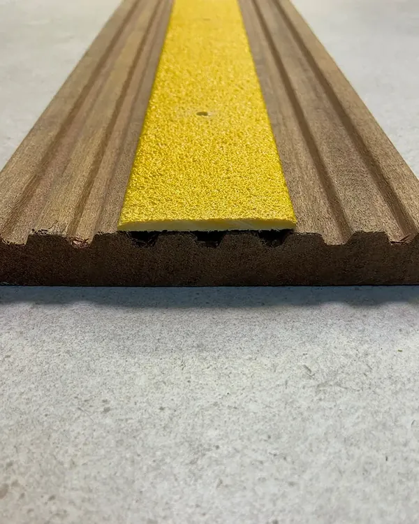 Yellow anti-slip strip inlaid in a hardwood decking board