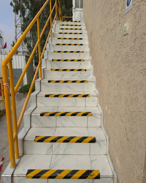 Yellow and black anti-slip GRP nosings on outdoor marble stairs in Qatar